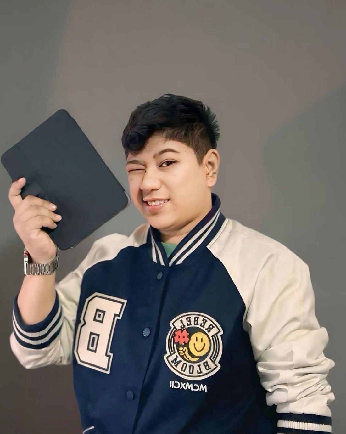 Cris Yap holding up a tablet and winking